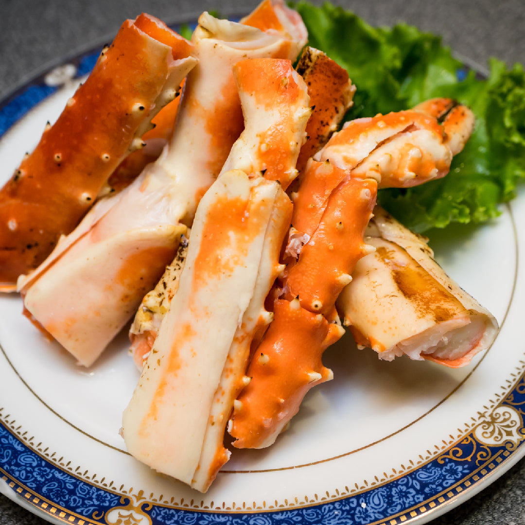 Live Alaskan king crab in a seafood tank with large claws and spiny red shell