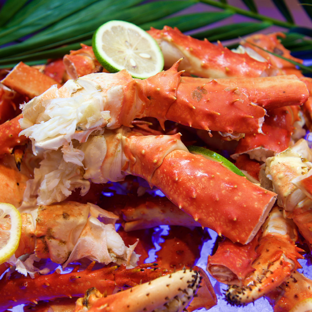 Steamed Alaskan king crab legs served on a plate with lemon wedges
