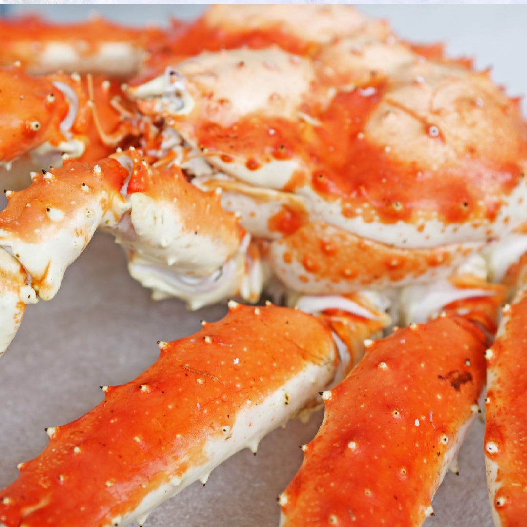 Budget-friendly king crab dinner at home: steamed king crab legs with garlic butter, lemon, and parsley on a rustic wooden table