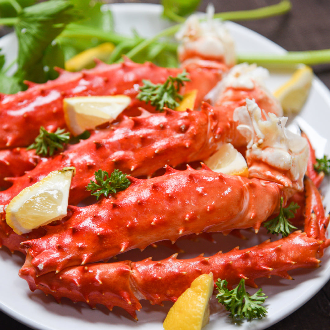 Fresh Alaskan king crab legs displayed at a seafood market counter with price tags, showing options for buying king crab locally or online
