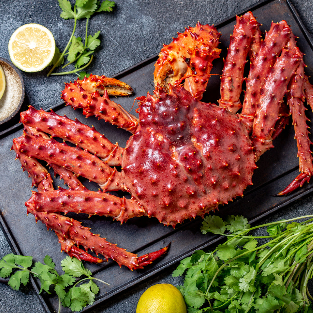 Alaskan red king crab legs on a plate with nutritional highlights: protein, omega-3, vitamin B12, zinc, and selenium icons