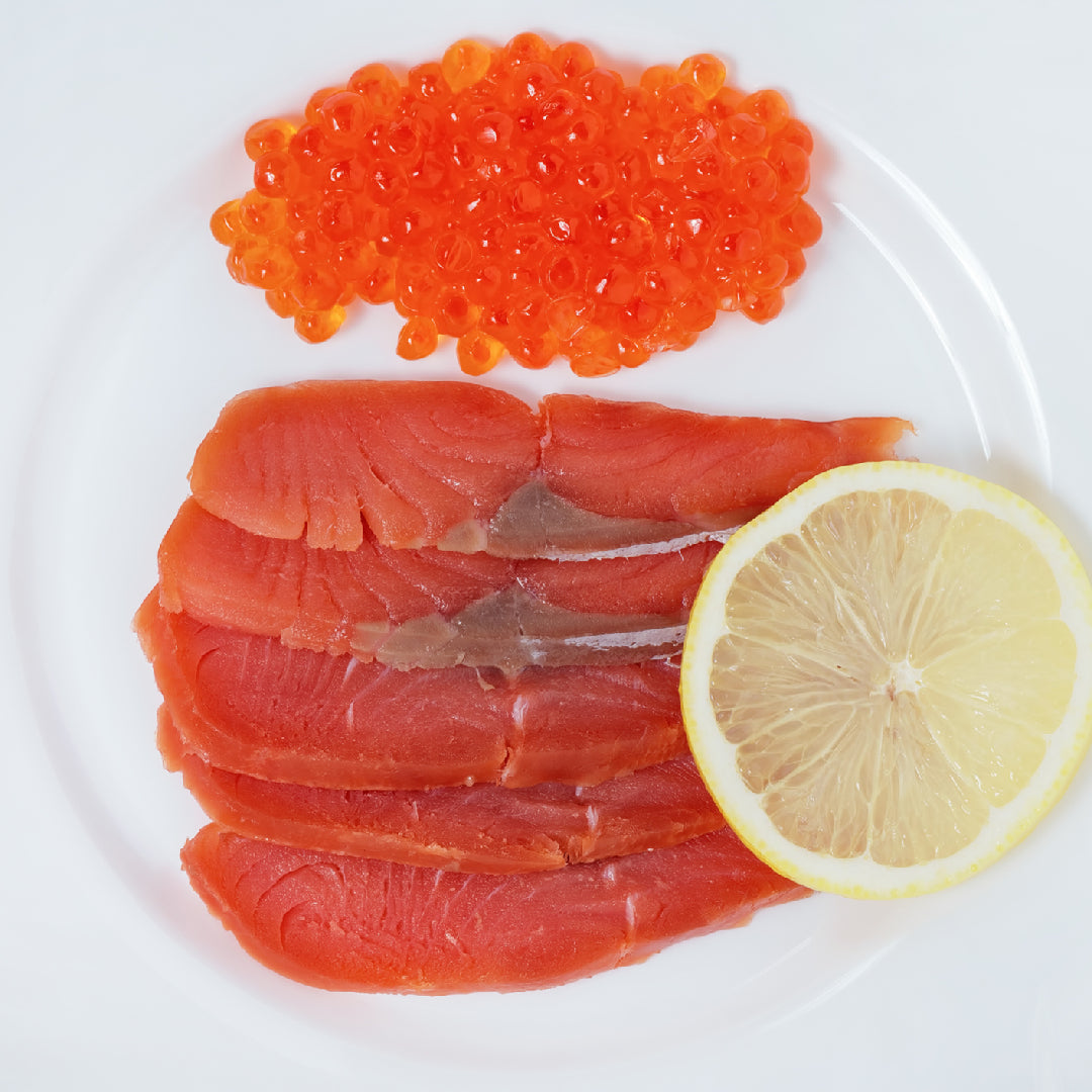 Fresh wild Alaskan King salmon fillet on a wooden board with lemon slices, herbs, and a nutrition facts overlay