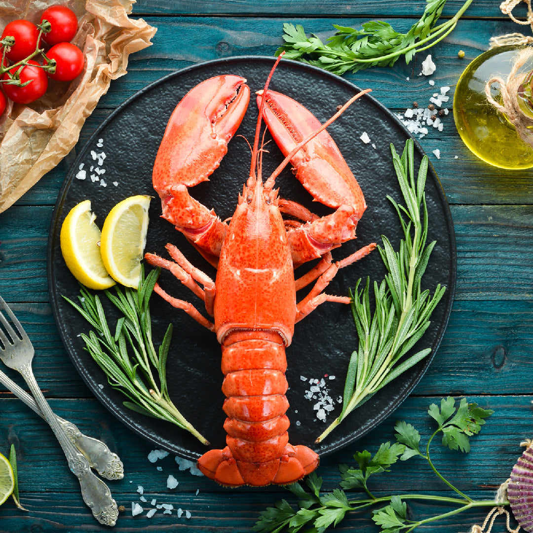 Bowl of rich creamy homemade lobster bisque garnished with chives and served with crusty bread