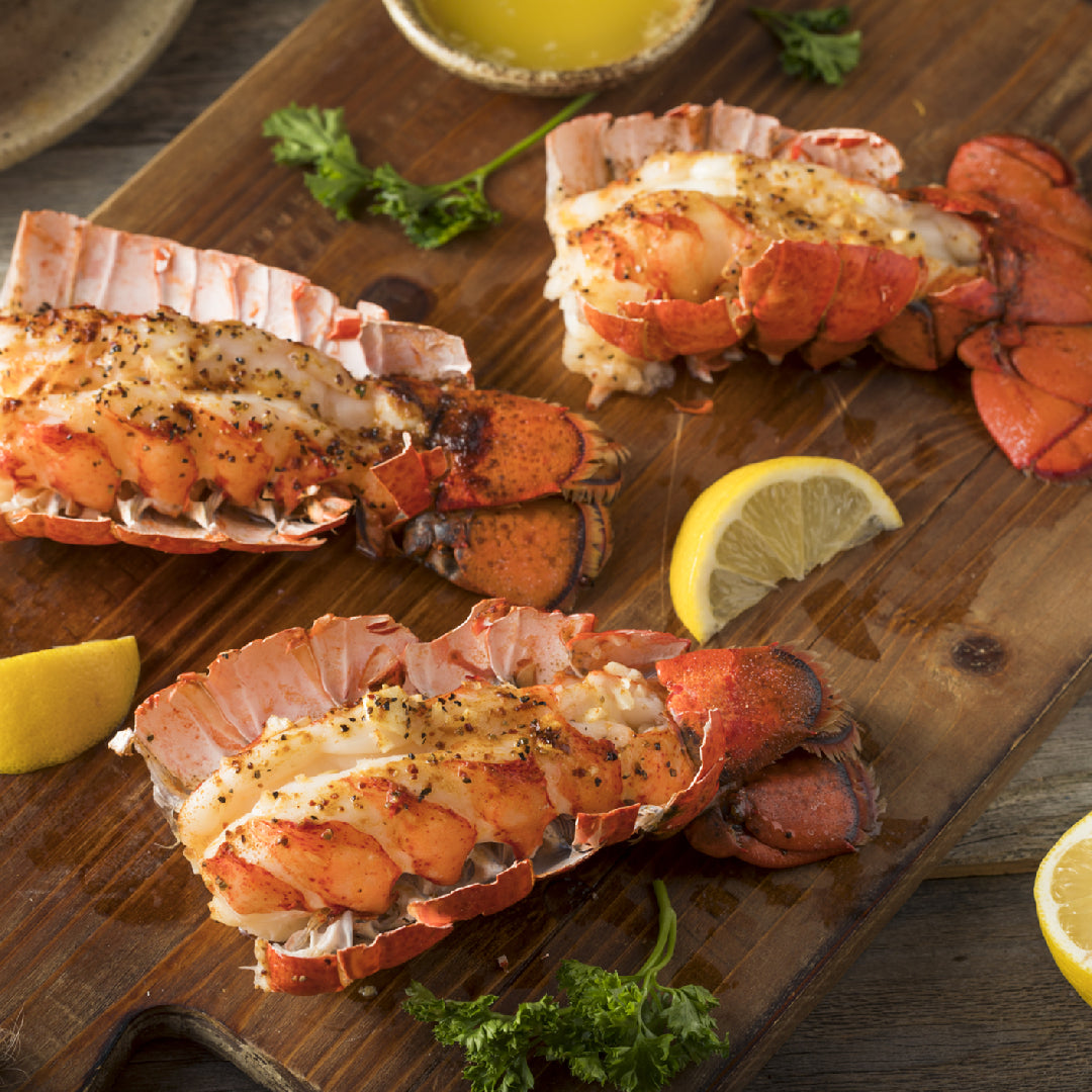 Lobster scampi with garlic butter sauce, fresh parsley, and lemon wedges served over pasta