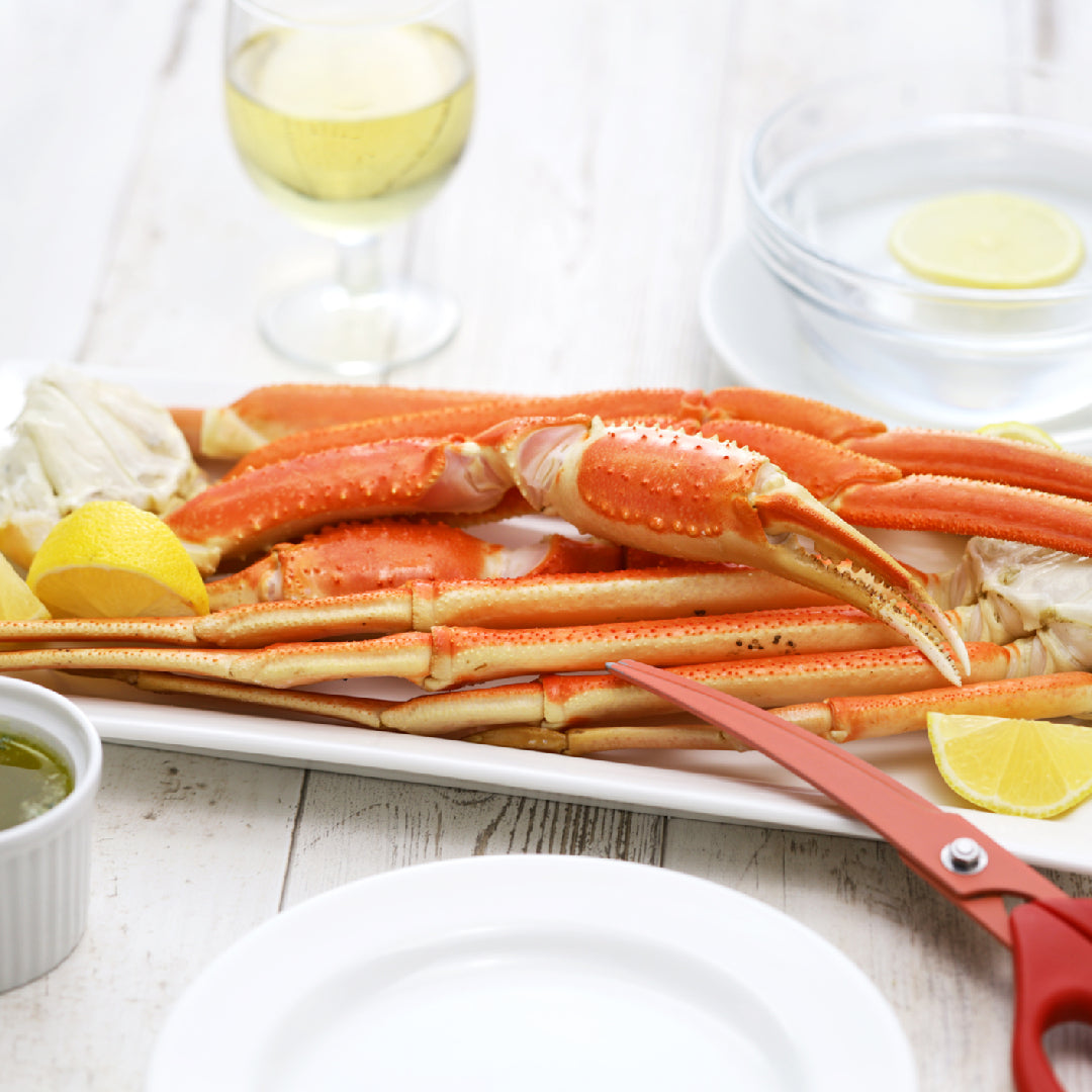 Snow crab legs and lobster tails plated side by side on a seafood dinner table