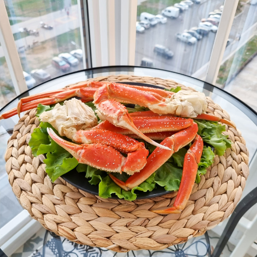 Snow crab legs served with garlic butter potatoes, grilled vegetables, and corn on the cob on a seafood dinner table