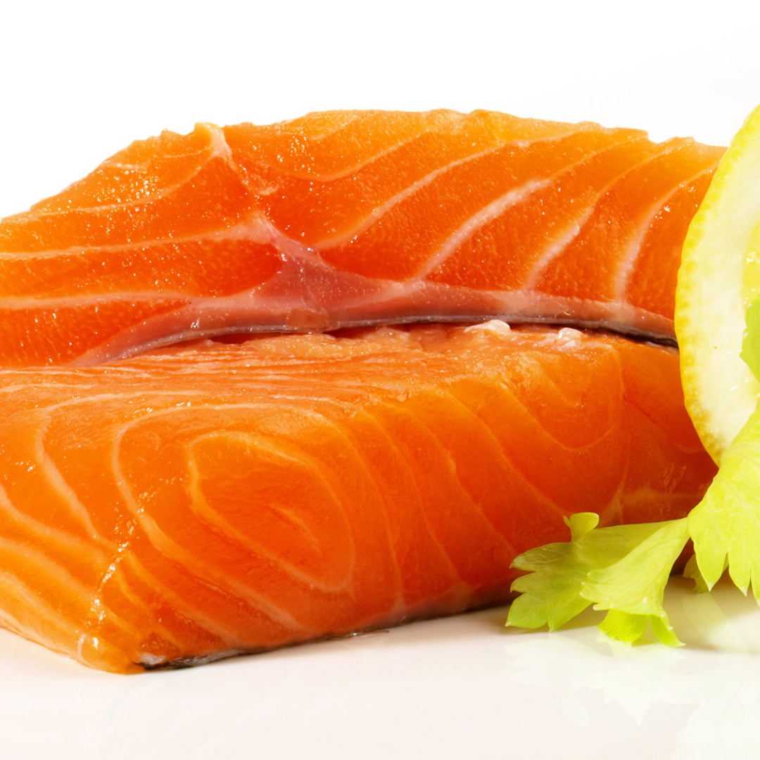 Whole roasted Ora King Salmon fillet garnished with fresh herbs and lemon as a holiday centerpiece