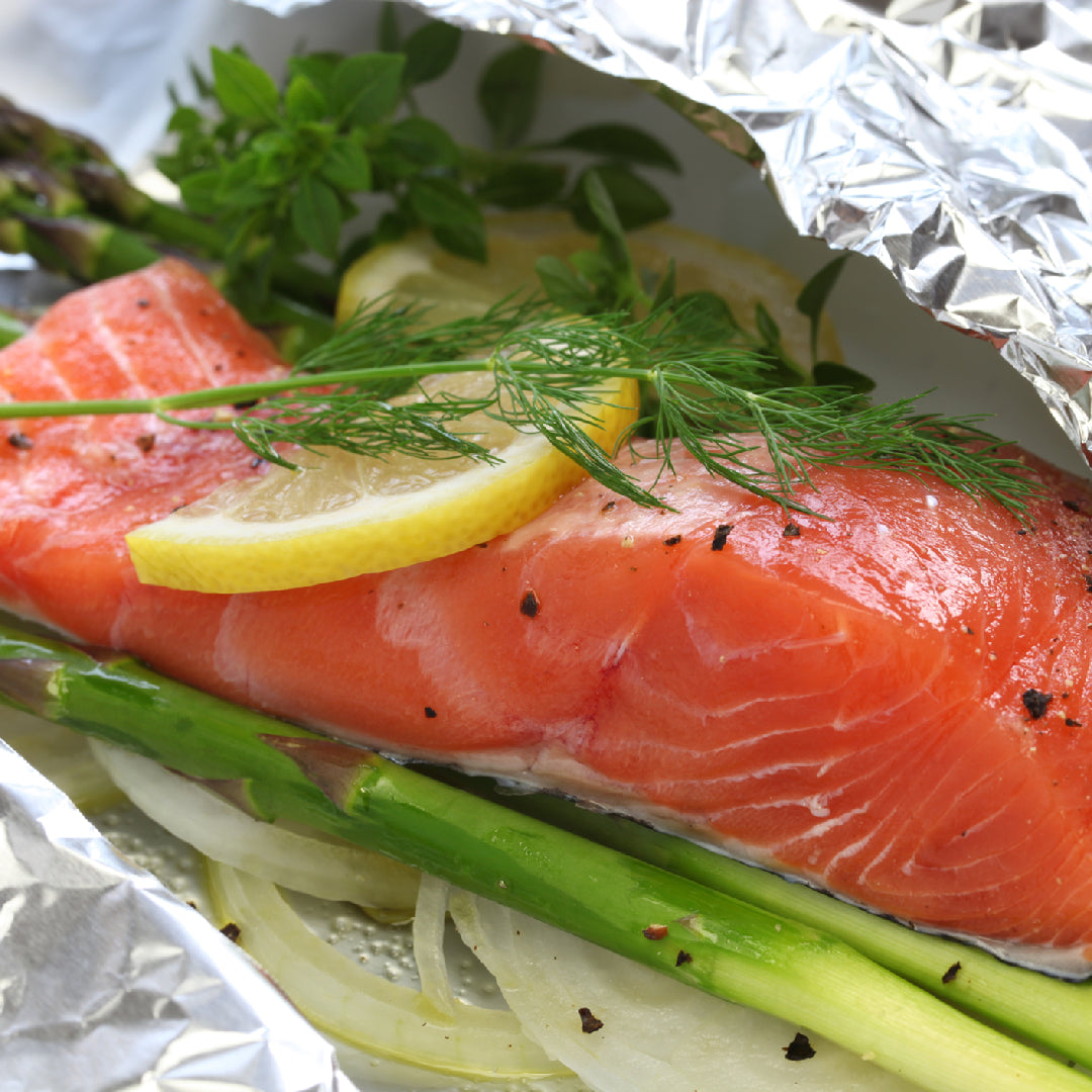 Beautifully plated seared Ora King Salmon fillet with citrus glaze, fresh herbs, and wild rice on a fine dining plate