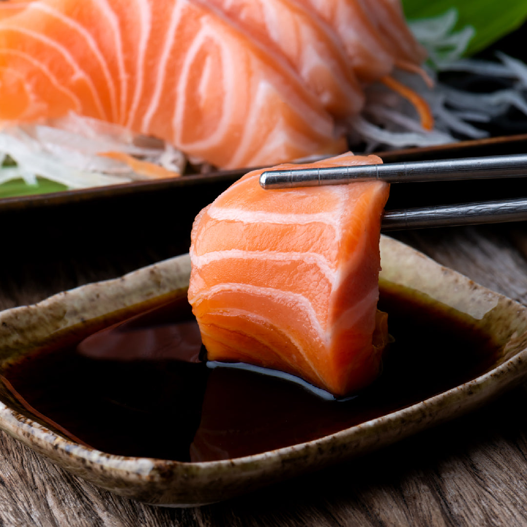 Fresh Ora King Salmon fillet wrapped in plastic wrap on a bed of crushed ice in a refrigerator for proper storage