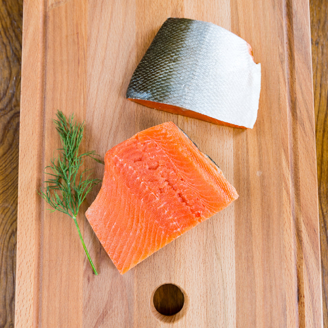 Perfectly seared Ora King Salmon fillet with golden crust and vibrant orange marbling on a plate