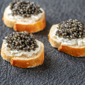 Close-up of Osetra caviar on a mother-of-pearl spoon, showcasing the variety in egg color from golden to dark brown, symbolizing luxury and gourmet dining