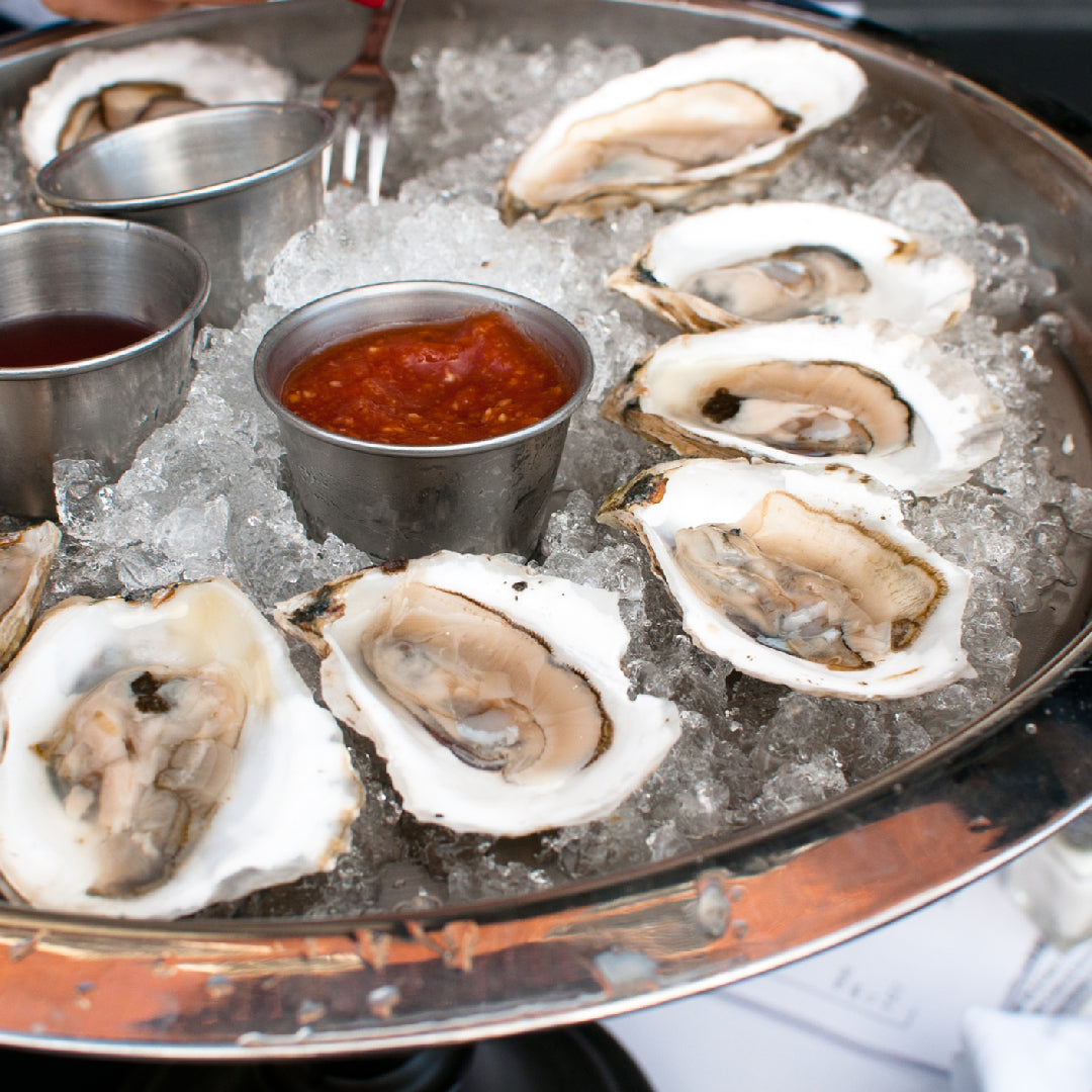 Fresh oysters on ice in a wooden crate, ready for home delivery