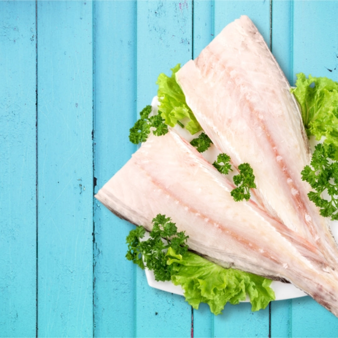 Fresh Pollock fish fillets ready for cooking on a cutting board