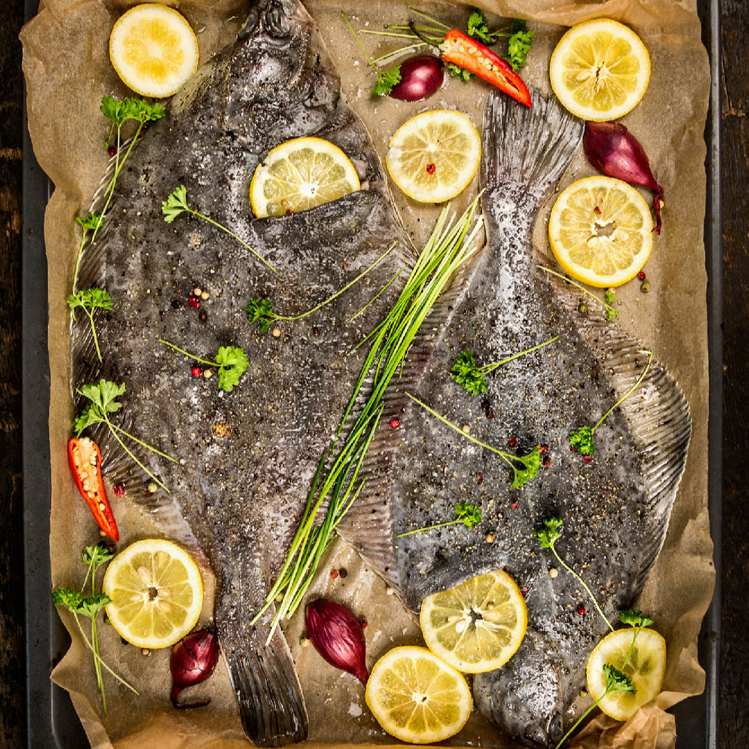 Fresh Petrale Sole fillets on ice with clear eyes and bright white flesh, displayed at a seafood market counter