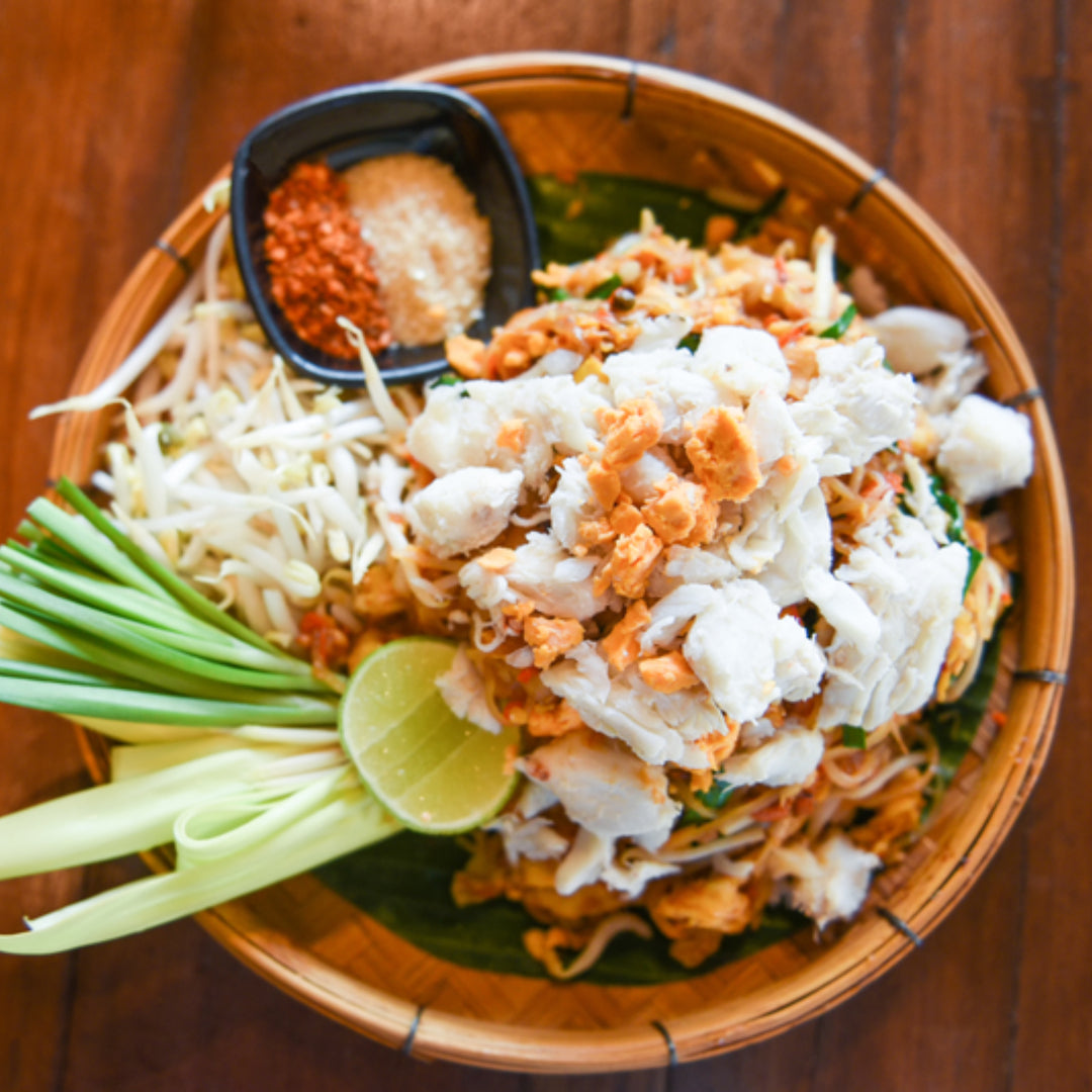 Snow crab fried rice with peas, carrots, and green onions in a wok
