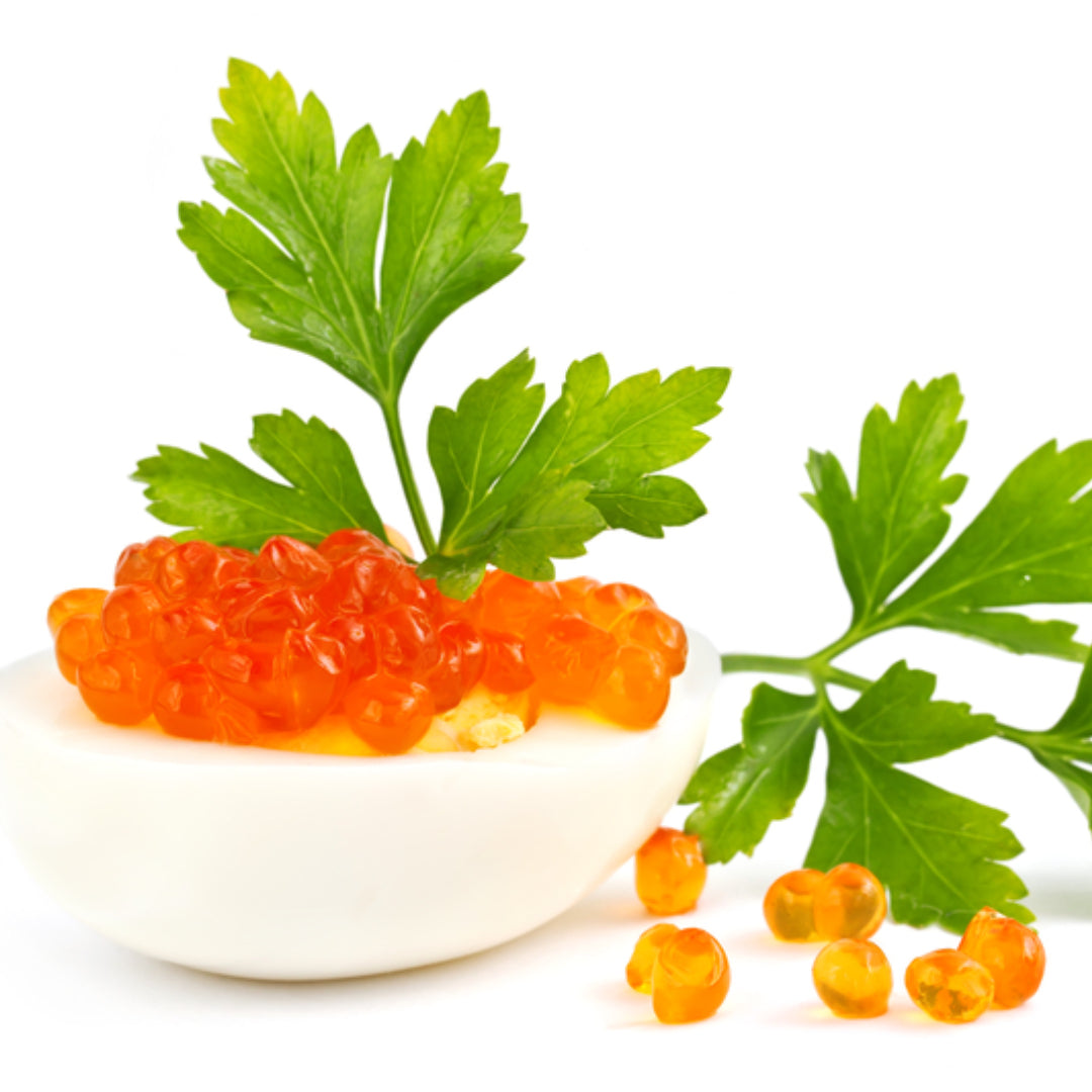 Ikura rice bowl topped with vibrant orange salmon roe pearls, crème fraîche, fresh dill, and a lemon wedge served in a ceramic bowl on a wooden table