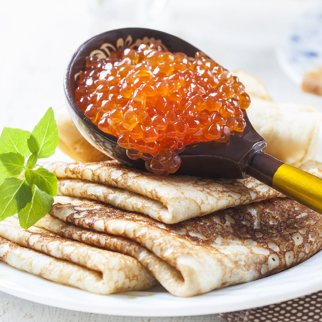 Fresh salmon roe (ikura) in a glass jar showing bright orange, firm eggs – premium red caviar sourced from Pacific Northwest wild-caught salmon
