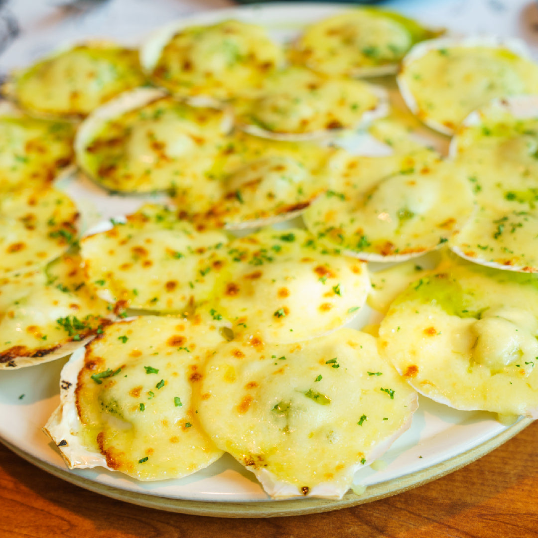 Perfectly grilled diver scallops with golden sear marks served with lemon wedges and fresh parsley