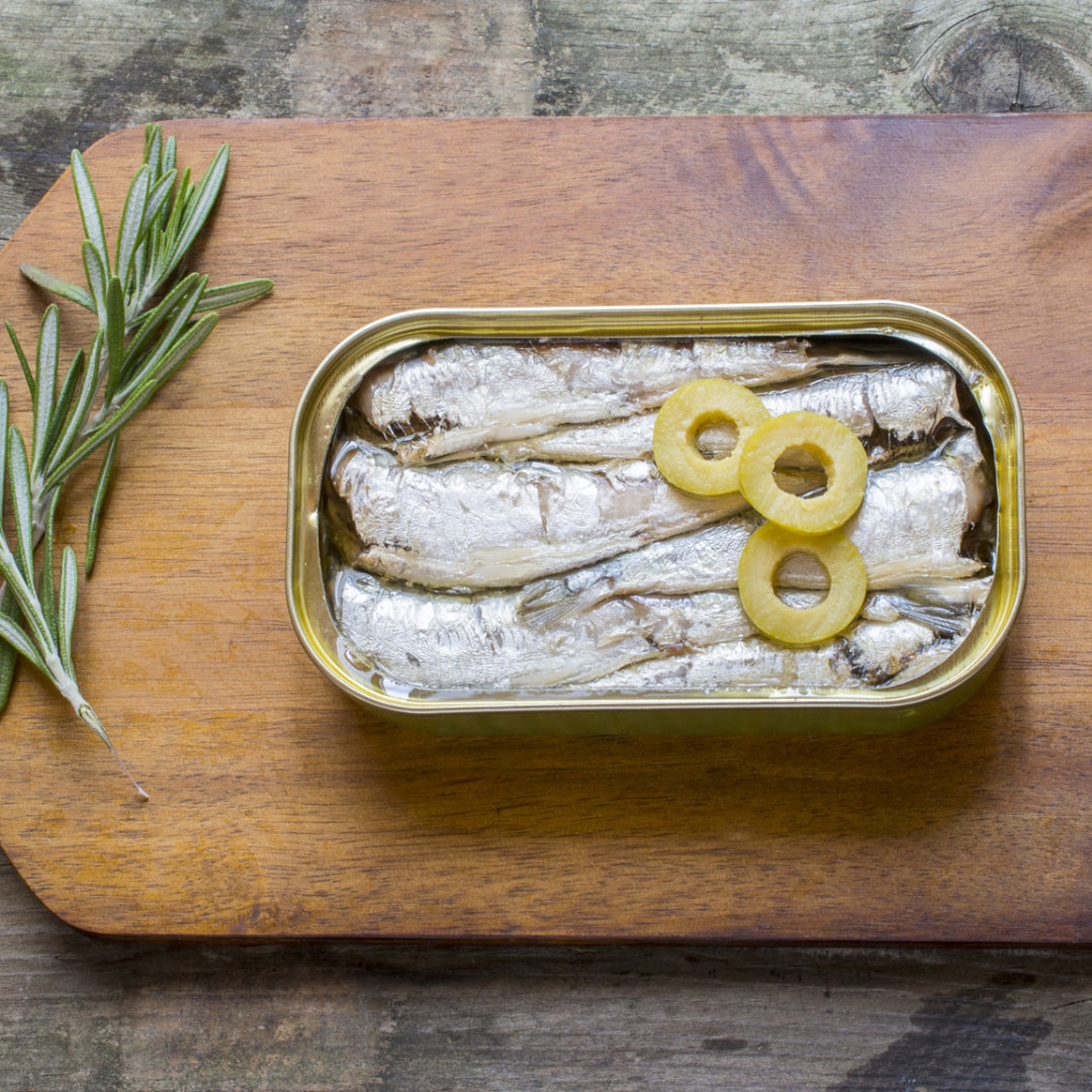 Creamy Portuguese sardine chowder in a bowl with diced potatoes, carrots, fresh parsley garnish, and crusty bread on the side