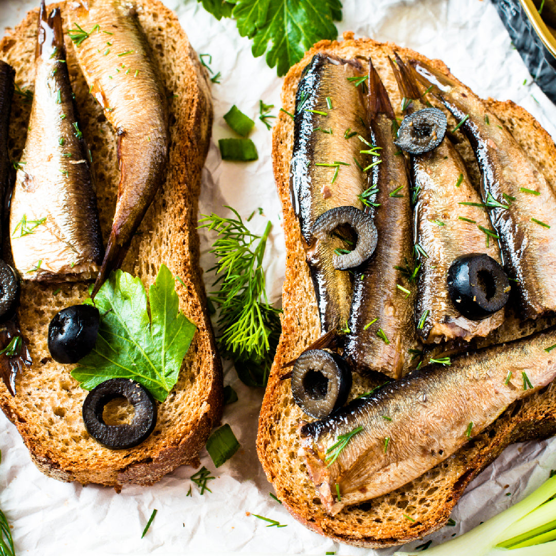 Toasted baguette slices topped with mashed sardines, diced tomatoes, fresh basil, and a drizzle of olive oil