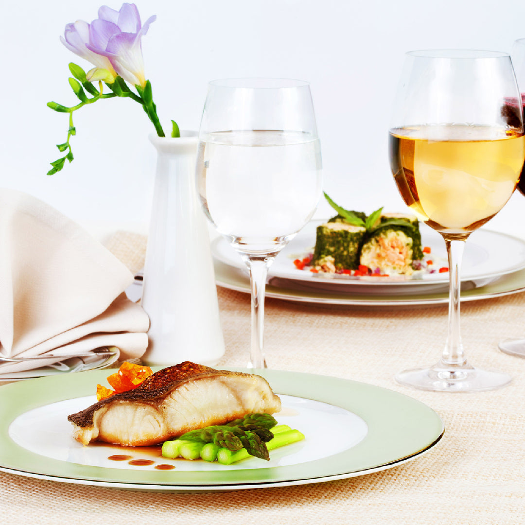 Side-by-side comparison of sablefish and halibut fillets on a wooden cutting board