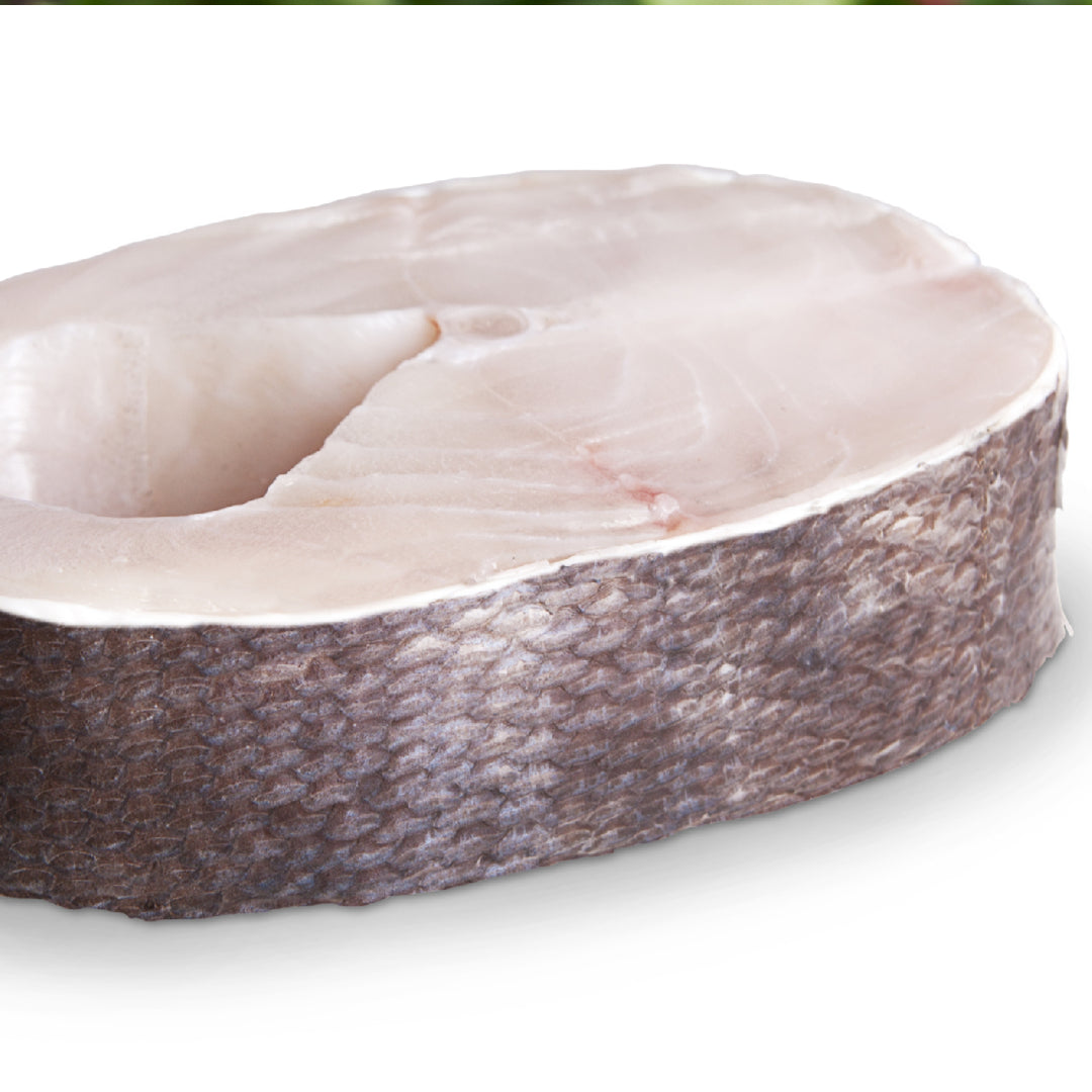 Side-by-side comparison of sablefish (black cod) and salmon fillets on a wooden board showing their different colors and textures