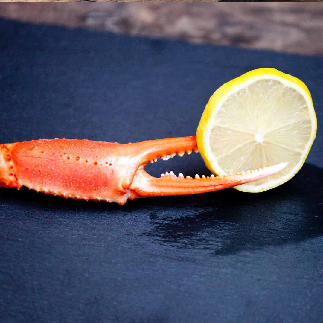 A festive snow crab legs feast spread on a table with drawn butter, corn, and seafood tools ready for guests