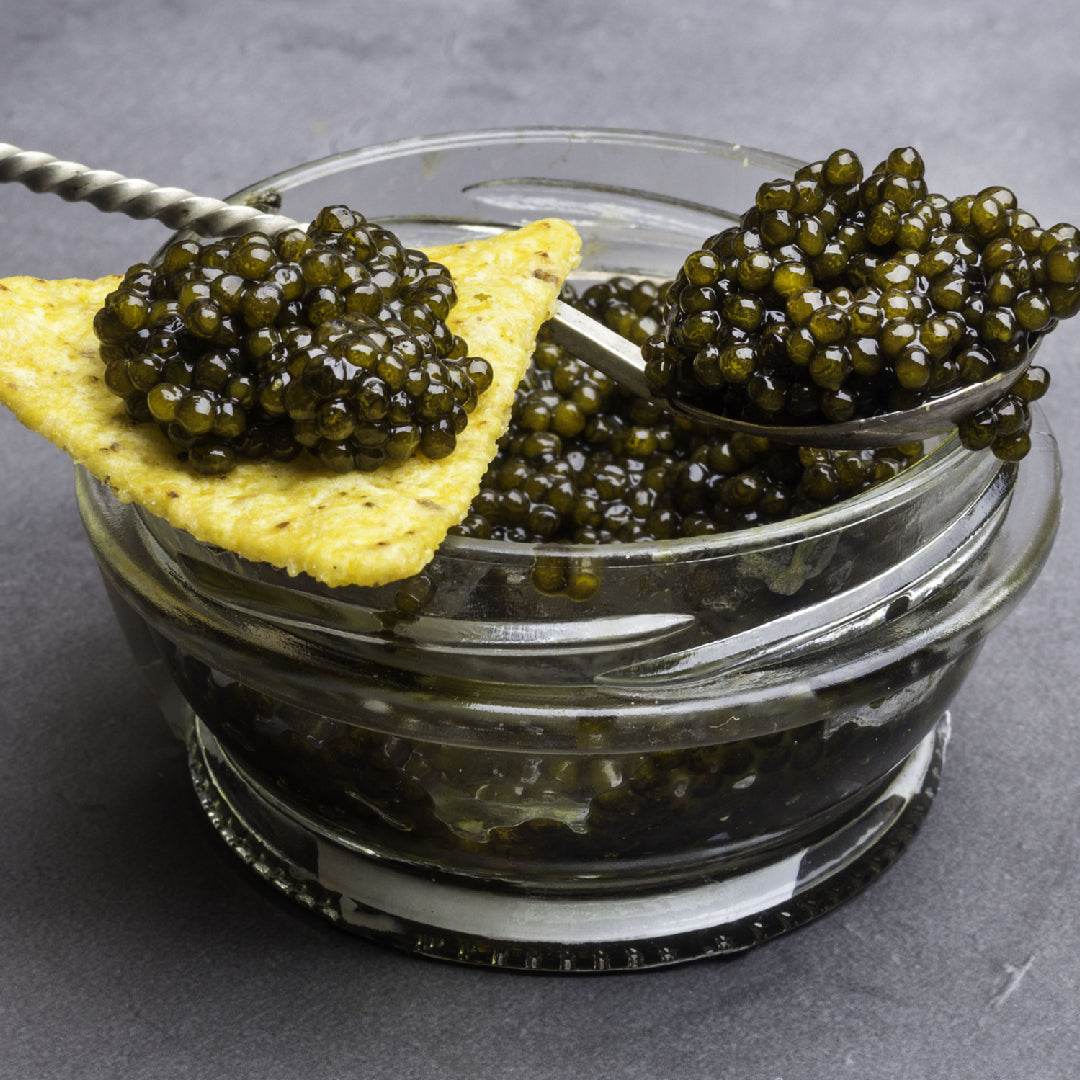 Elegant sturgeon caviar served on blinis with crème fraîche and chives on a luxury dinner party spread