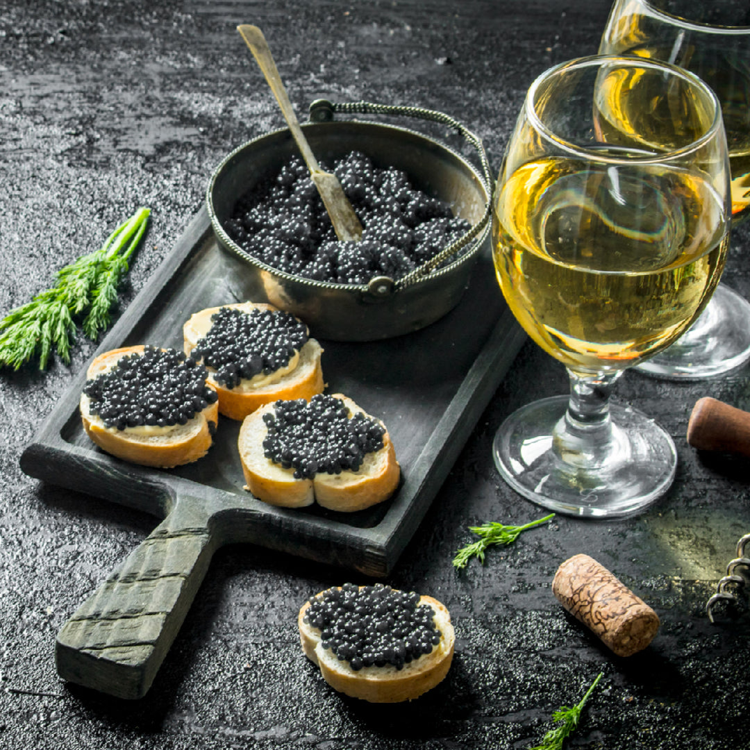 Premium sturgeon caviar tin elegantly presented as a luxury gift box with mother-of-pearl spoon, blinis, and Champagne on a decorated table