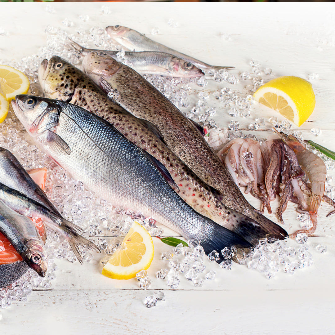 Seafood gift set featuring premium caviar tin, smoked salmon, and king crab legs alongside a seafood knife set and cookbook — the best gifts for seafood-loving chefs combine premium ingredients with quality kitchen tools