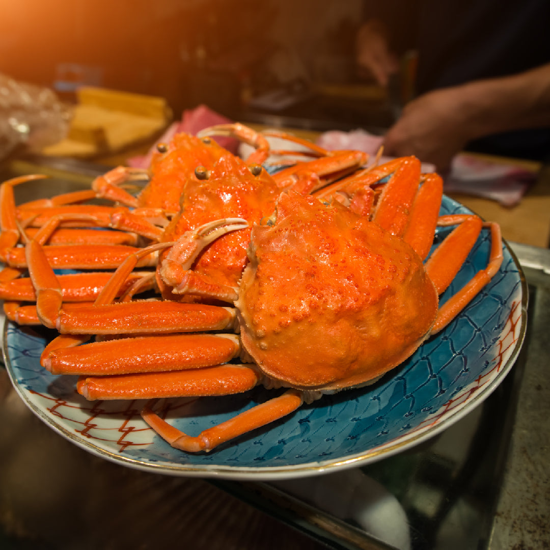 Cooked snow crab legs on a serving platter with lemon wedges and melted butter dipping sauce
