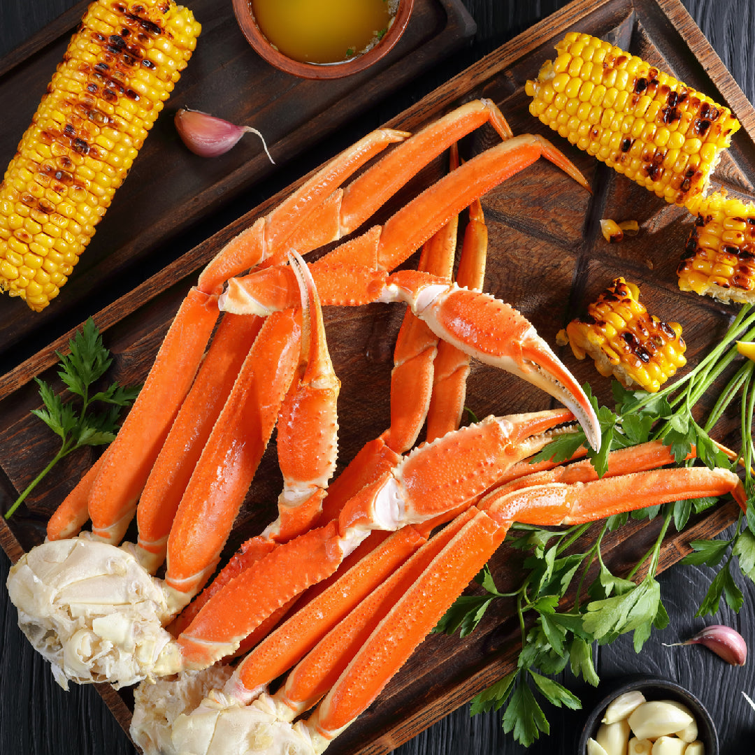 Snow crab legs being reheated in a steamer basket over boiling water, ready to serve with melted butter