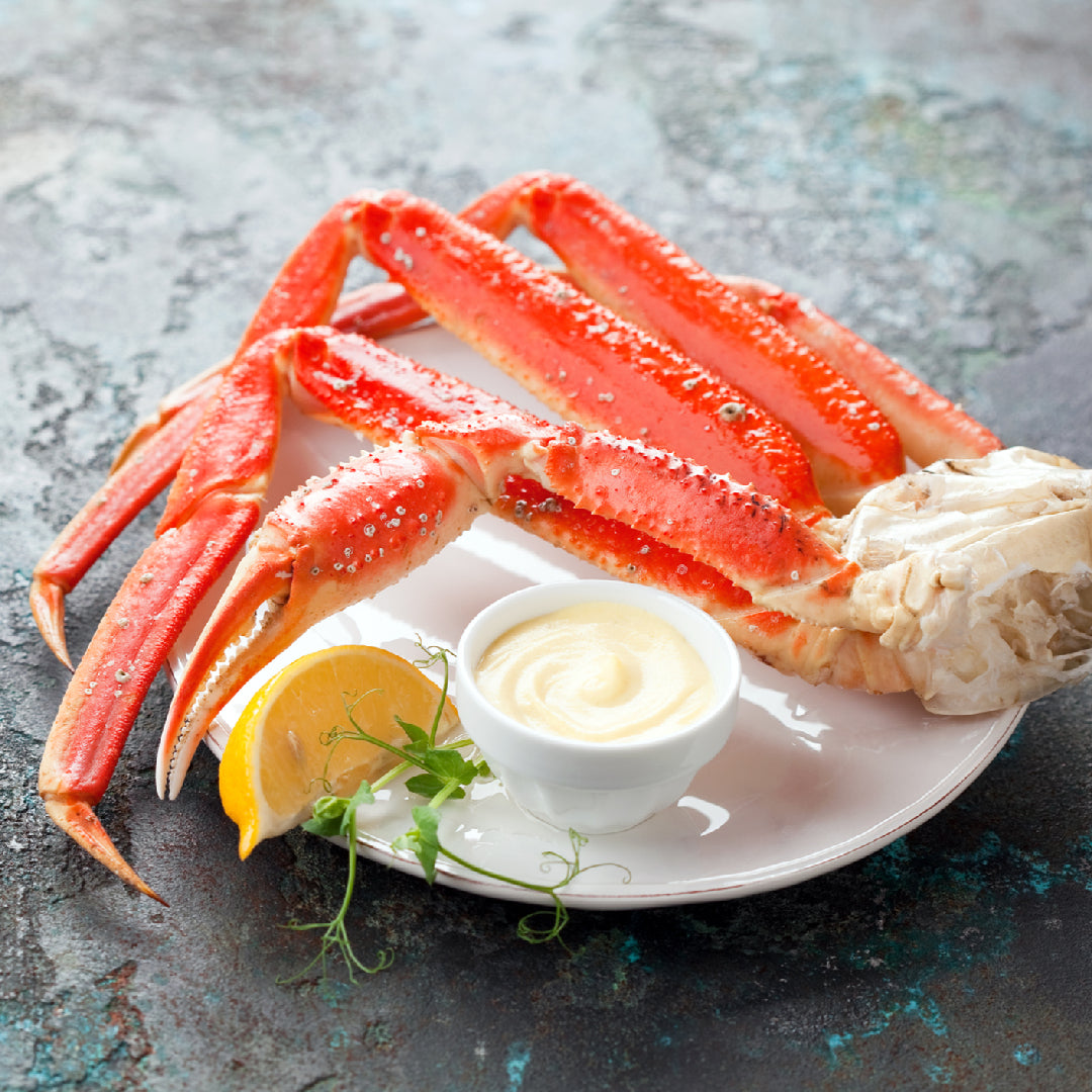 Snow crab legs and Alaskan king crab legs side by side on ice, comparing size and texture