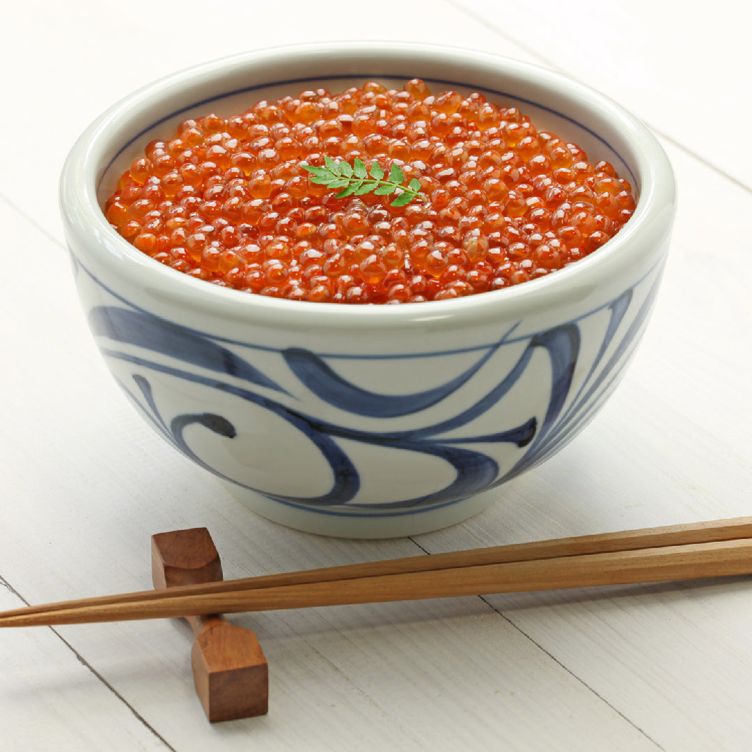 Multiple varieties of salmon roe in small glass bowls showing the color and size differences between Chum, Coho, Pink, and Trout caviar