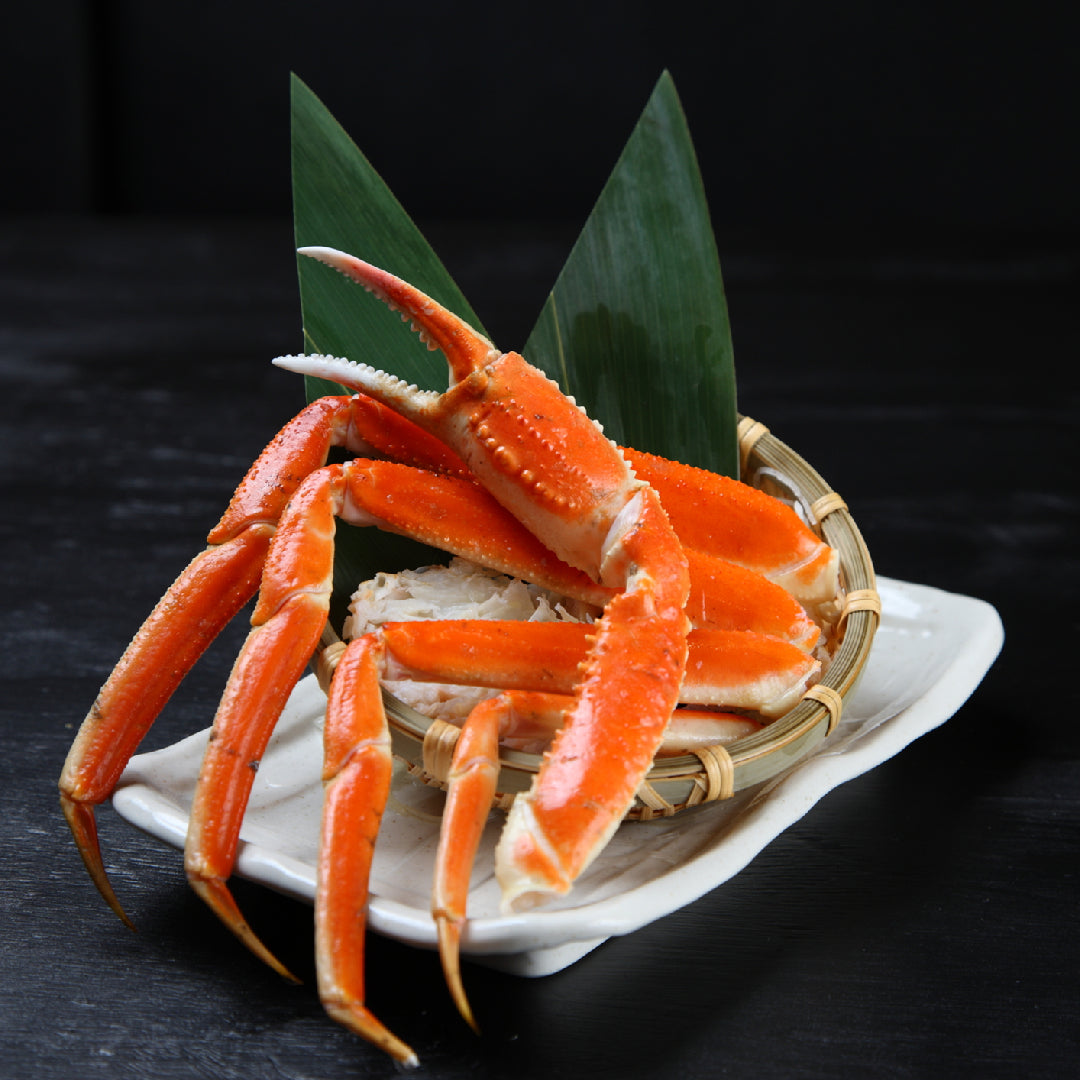 Snow crab leg clusters being placed into a heavy-duty freezer bag with air pressed out, ready for long-term freezer storage