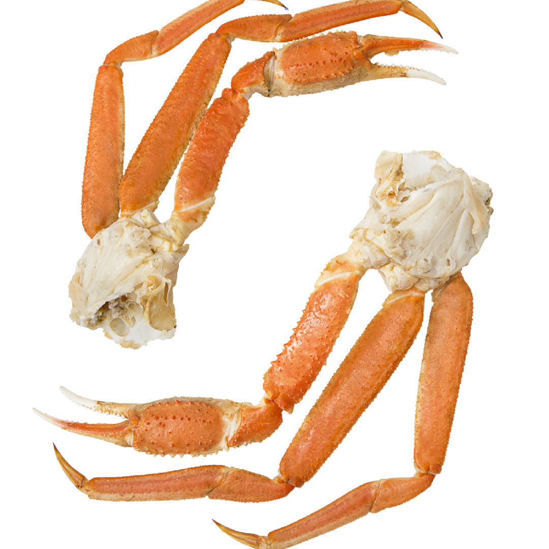 Large platter of steamed snow crab legs served with melted butter and lemon wedges for a crowd