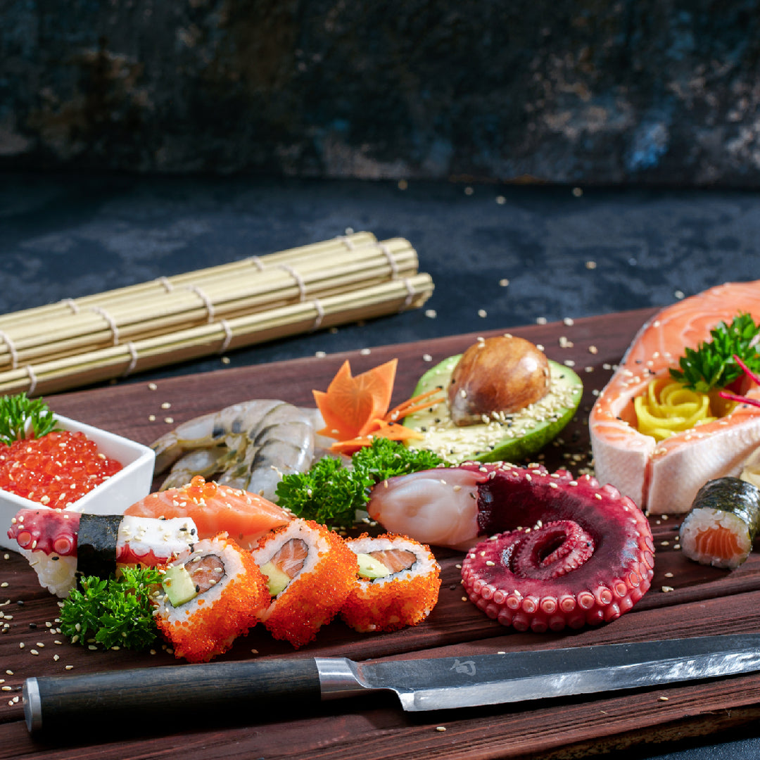 Assorted nigiri and sashimi platter with tuna, salmon, and yellowtail on a slate board