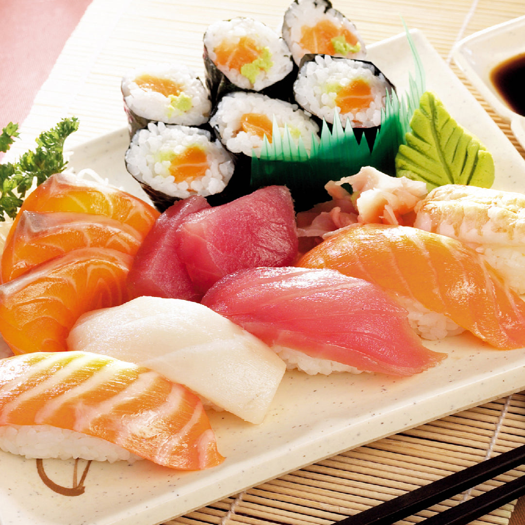 Assorted sushi platter with nigiri, sashimi, and maki rolls served on a wooden board