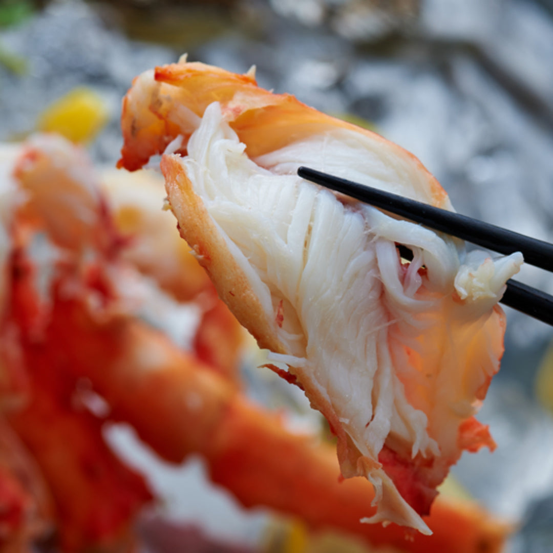 Fresh tender crab meat in a bowl with lemon wedges and herbs on a wooden cutting board