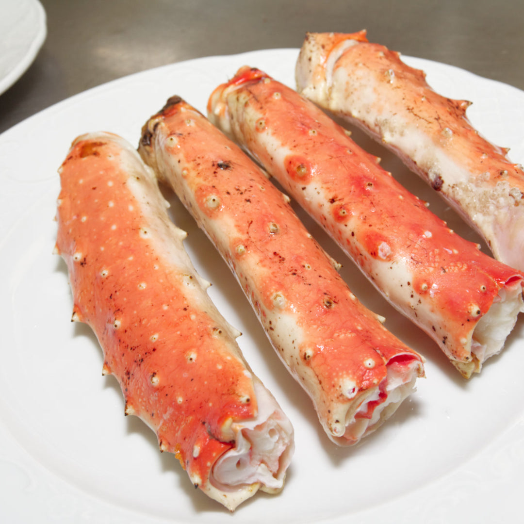 A live crab on a cutting board with seafood tools and lemon slices