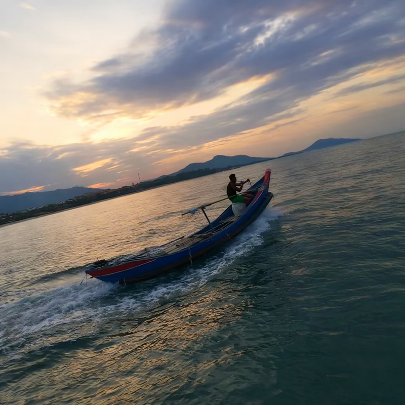 Small Vietnamese fishing boat leaving Lang Co Bay at dusk heading into the South China Sea