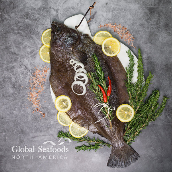Freshly caught Petrale sole served on a plate with rosemary, lemon slices, and red chili peppers, prepared for a flavorful seafood dish