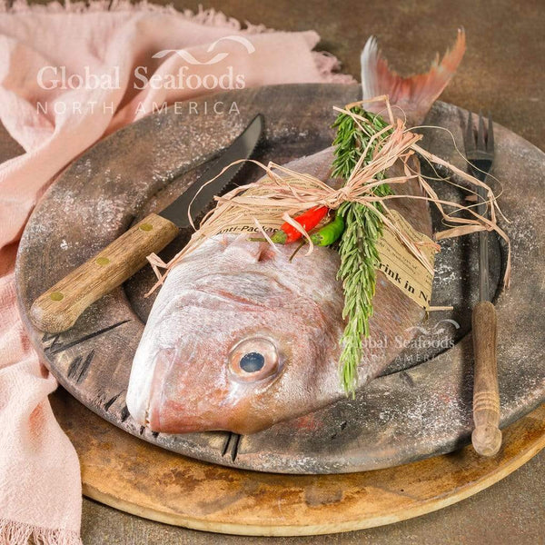 Whole fresh New Zealand snapper on a serving plate, showing natural skin color and whole-fish presentation