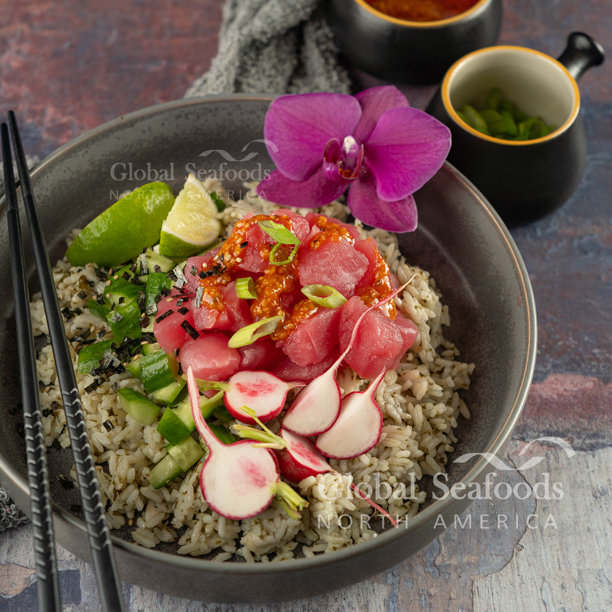 Tuna poke bowl with rice, radish slices, avocado and lime
