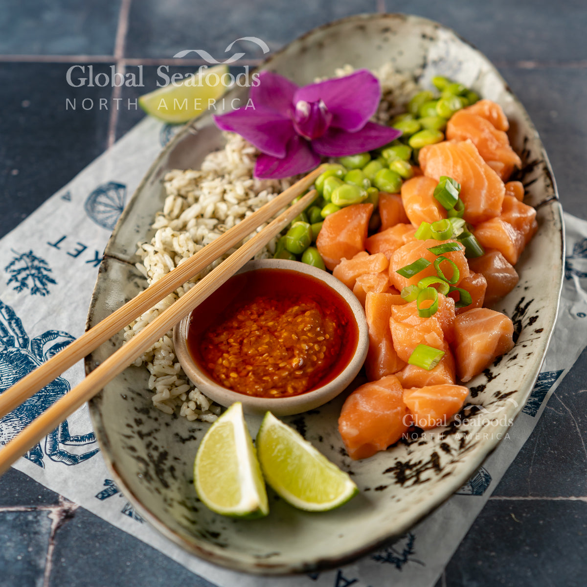 Atlantic salmon poke cubes with rice, edamame, green onion, lime and a separate bowl of sauce — serving suggestion.