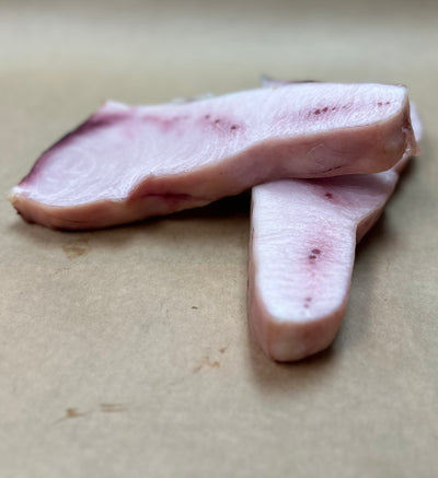 High-quality swordfish steaks, dry-aged and neatly arranged on a light brown board, ready for gourmet cooking