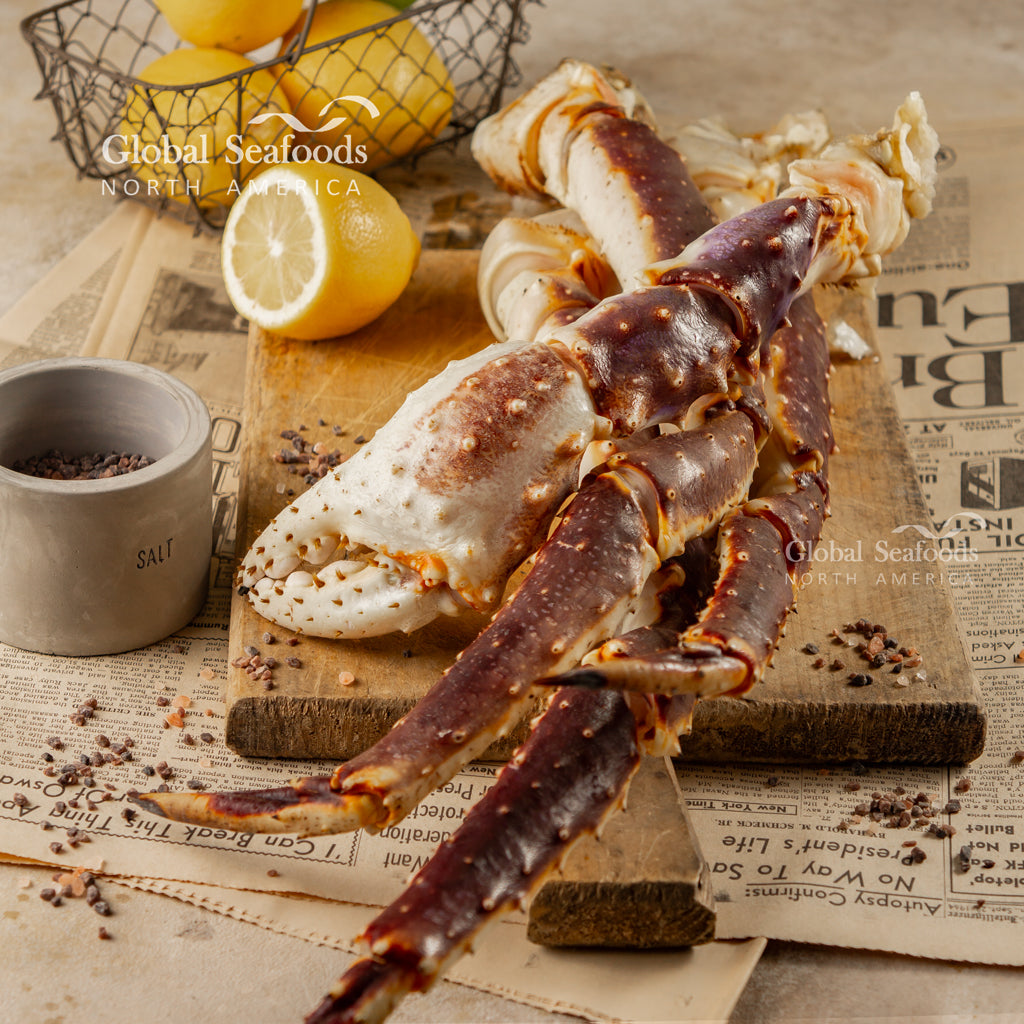 Raw king crab legs on a cutting board with lemon