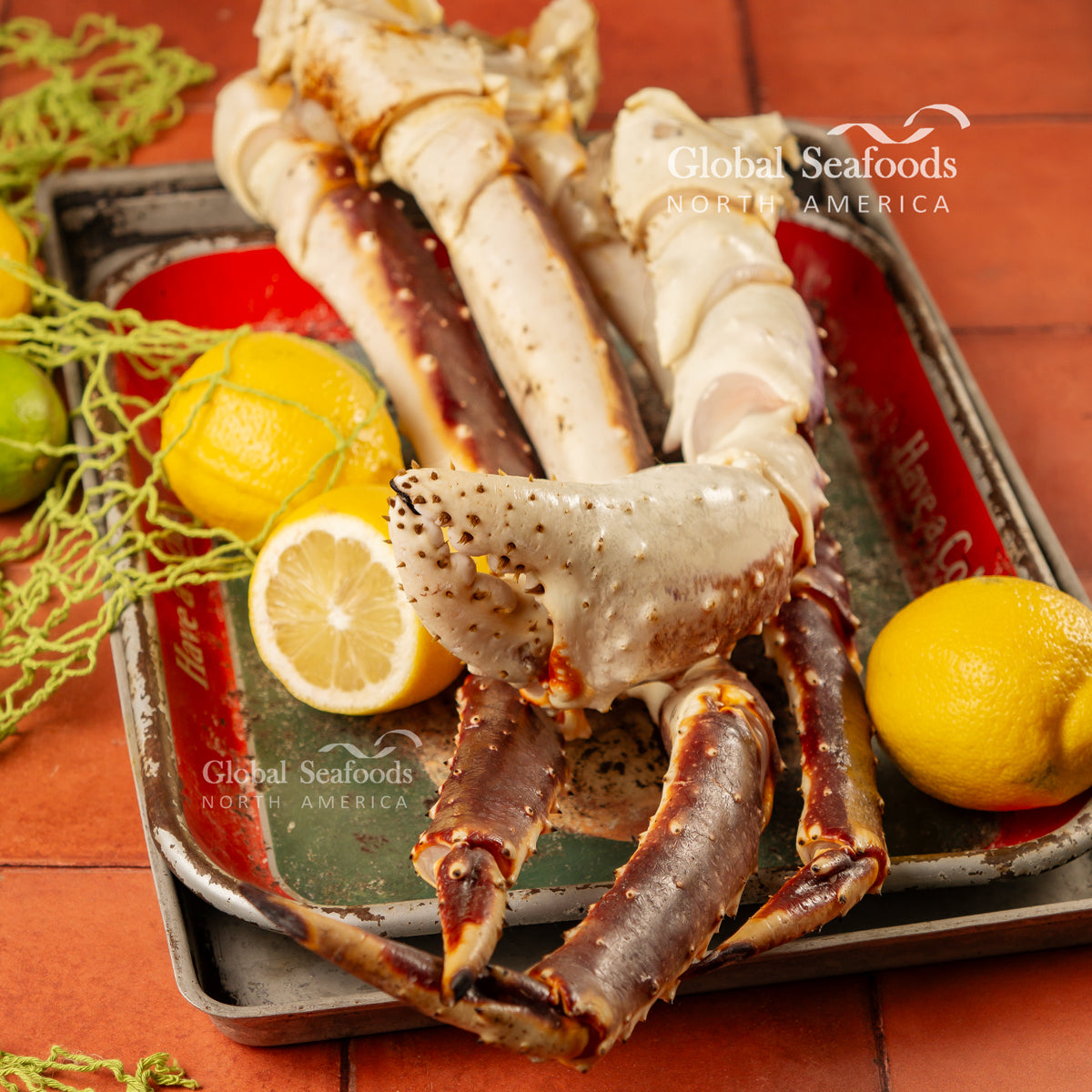 Raw king crab legs on a metal tray with lemon