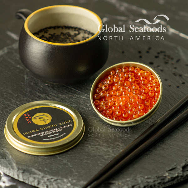 Open tin of Ikura Shoyu Zuke salmon roe beside its labeled lid, a black cup and chopsticks