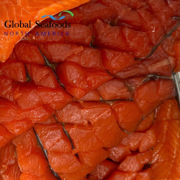 Stacked pieces of cold-smoked Yakutia-style salmon fillets with skin on, showing rich color and traditional slicing